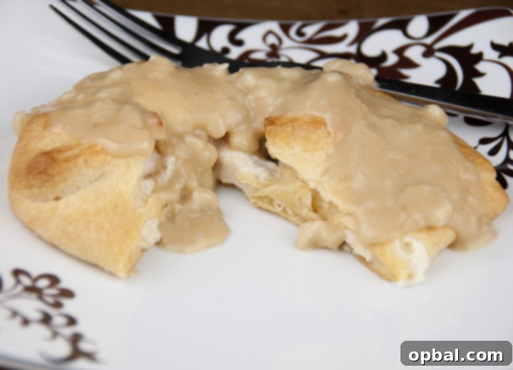 Savory Chicken Crescent Bites 3 Close-up of a freshly baked Chicken Stuffed Crescent Roll, showing the creamy chicken mixture peeking out from the tender crescent dough – a delicious on-the-go meal.