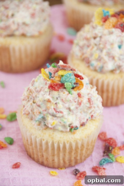 Fruity Pebble Fantasy Vanilla Cupcakes 2 Easy vanilla cupcake recipe topped with vibrant Fruity Pebbles Buttercream Frosting, perfect for a fun St. Patrick's Day dessert or kids' party.
