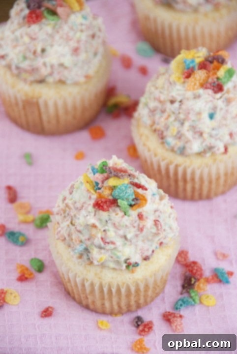 Fruity Pebble Fantasy Vanilla Cupcakes 4 Vanilla Cupcakes with a generous swirl of Fruity Pebbles Buttercream Icing, highlighting the colorful cereal pieces for a fun, festive treat.