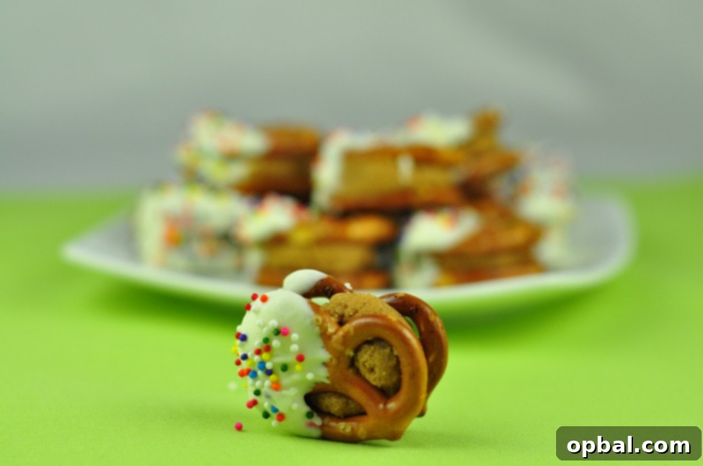 White Chocolate Biscoff Pretzel Bites Arrangement of White Chocolate Biscoff Pretzel Bites on a plate, with some adorned with colorful sprinkles.