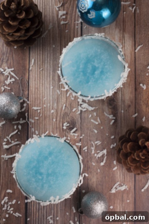 Arctic Blue Coconut Dream 3 Close-up of a festive Blue Christmas Coconut Cocktail with frosted rim and coconut flakes, ideal for holiday parties.