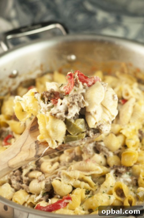 Creamy Philly Cheesesteak Pasta 3 Philly Cheesesteak Pasta: Close-up of cheesy pasta loaded with tender beef, bell peppers, and onions.
