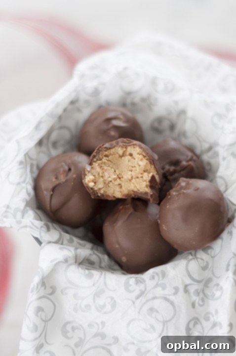Easy Peanut Butter Krispie Bites 4 A plate full of golden No-Bake Peanut Butter Rice Krispie Balls, ready to be dipped in chocolate.