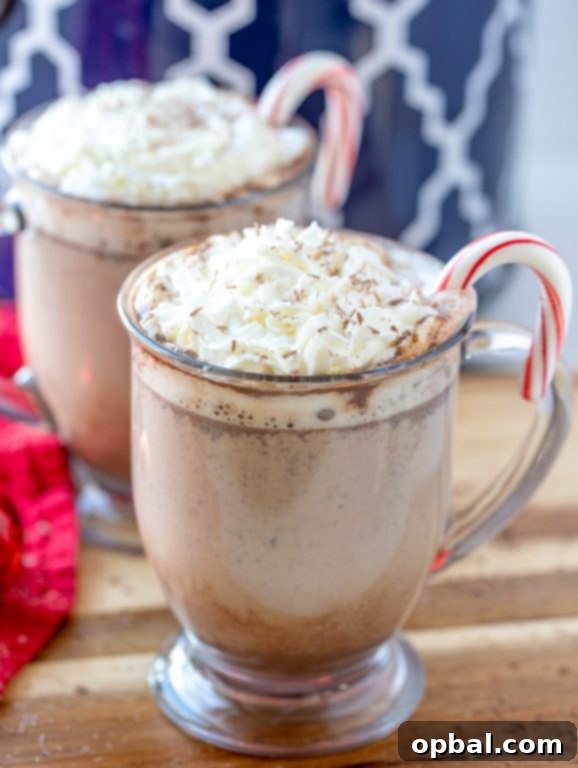 Cozy Slow Cooker Peppermint Mochas 2 A steaming mug of slow cooker peppermint mocha garnished with whipped cream, chocolate shavings, and a candy cane, perfect for holiday parties.