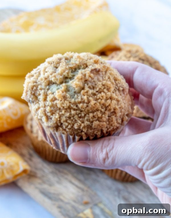 Freshly baked banana crumb muffins arranged on a rustic wooden board, ready to be enjoyed.