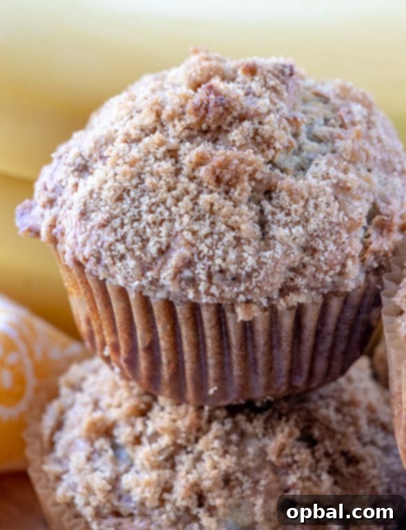 An inviting image of a single banana crumb muffin, highlighting its moist interior and crunchy topping.