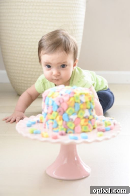 Magical Marshmallow Layer Cake 4 Child reaching for a slice of Lucky Charms layer cake decorated with colorful cereal marshmallows