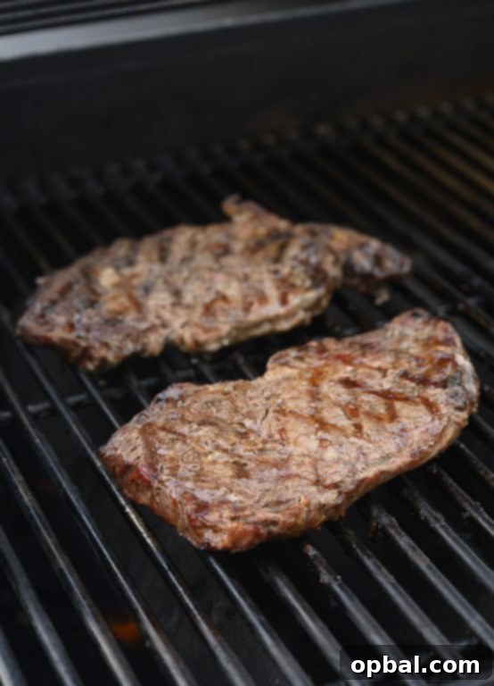 Charred Ribeye with Bold Blue Cheese Onion Cream 4 Ribeye steaks searing perfectly on a hot Weber grill, creating beautiful grill marks.
