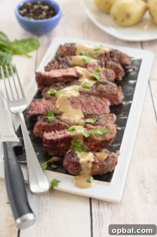 Charred Ribeye with Bold Blue Cheese Onion Cream 7 Two grilled ribeye steaks, one with onion blue cheese sauce, plated alongside a fresh green salad for a complete summer meal.