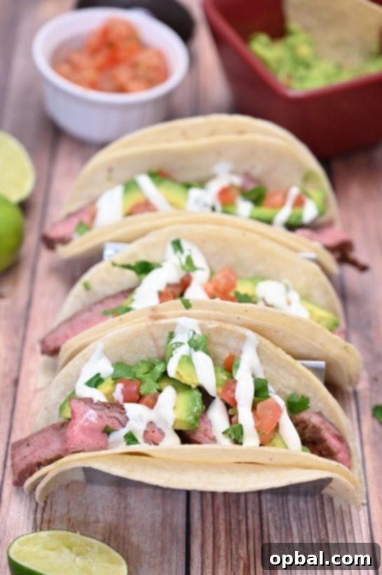 Sizzling Flank Steak Tacos with Cool Avocado and Bright Cilantro Lime Crema 3 Close-up shot of grilled flank steak tacos with fresh toppings, ready to be enjoyed.