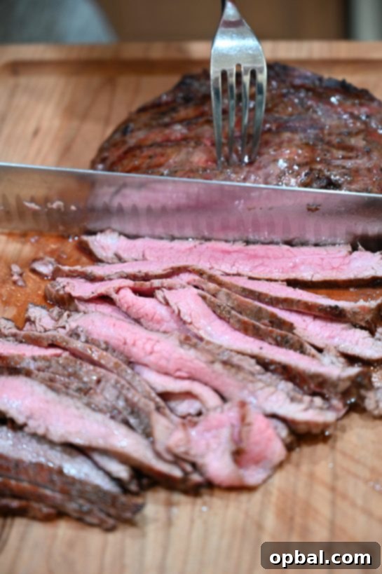 Sizzling Flank Steak Tacos with Cool Avocado and Bright Cilantro Lime Crema 4 Expertly slicing grilled flank steak against the grain to maximize tenderness and flavor.