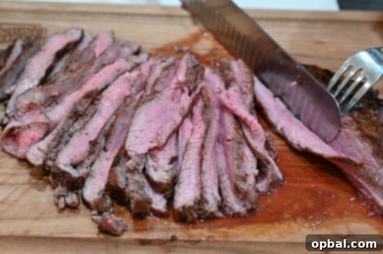 Sizzling Flank Steak Tacos with Cool Avocado and Bright Cilantro Lime Crema 5 Perfectly cooked medium-rare grilled flank steak, thinly sliced against the grain, showcasing its juicy interior.