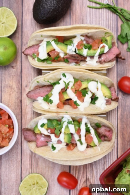 Sizzling Flank Steak Tacos with Cool Avocado and Bright Cilantro Lime Crema 6 Close-up of a beautifully assembled grilled flank steak taco, loaded with avocado and drizzled with cilantro lime crema, promising a burst of fresh flavors.