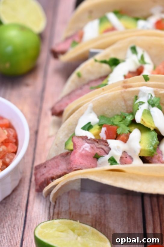 Sizzling Flank Steak Tacos with Cool Avocado and Bright Cilantro Lime Crema 8 An array of delicious gluten-free grilled flank steak tacos, topped with fresh avocado and cilantro lime crema, arranged for a beautiful and flavorful presentation.