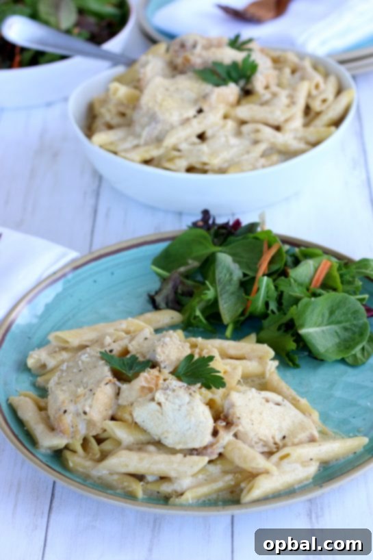 Slow Cooker Creamy Chicken Alfredo 11 Chicken Alfredo plated with a side salad.
