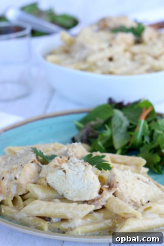Slow Cooker Creamy Chicken Alfredo 13 Chicken Alfredo plated with a side salad for an easy crock pot pasta dinner recipe.