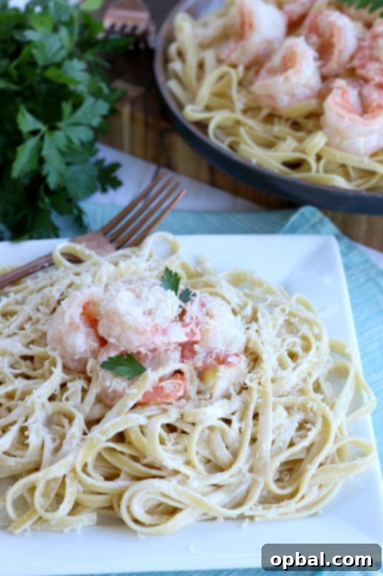Garlic Butter Shrimp in a Velvety Cream Sauce 2 A beautifully plated dish of creamy garlic butter shrimp served over pasta, garnished with fresh parsley and lemon wedges, ready to be enjoyed as a delightful dinner.