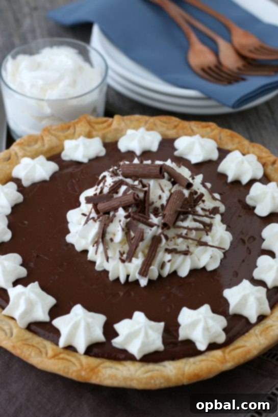 Decadent Chocolate Silk Pie 12 A stunning homemade chocolate pie, also known as old-fashioned chocolate pie, beautifully presented. This easy-to-make dessert features luscious homemade chocolate pudding and is elegantly topped with fluffy whipped cream, perfectly ready to be served and enjoyed.