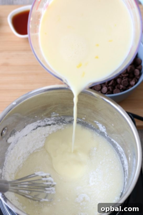 Decadent Chocolate Silk Pie 6 A vibrant image showing wet ingredients being skillfully mixed into the rich batter for the old-fashioned chocolate pie, highlighting the beginning stages of the pudding creation.