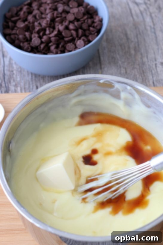 Decadent Chocolate Silk Pie 7 The next crucial step in preparing the chocolate pie: adding rich butter and fragrant vanilla extract to the smooth, simmering chocolate pudding mixture.