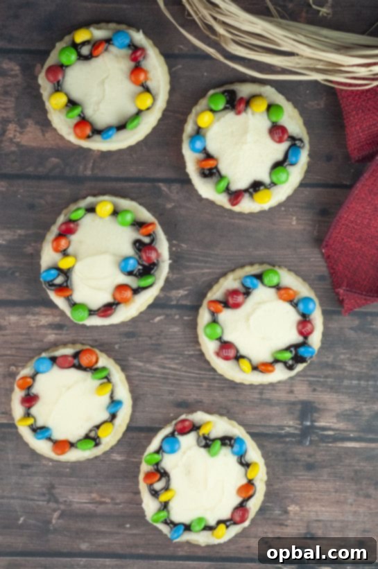Twinkling Christmas Light Cookies 2 Christmas Light Bulb Cookies recipe are a fun and easy treat to make with kids for the holidays, featuring vibrant M&Ms as lights and no royal icing.