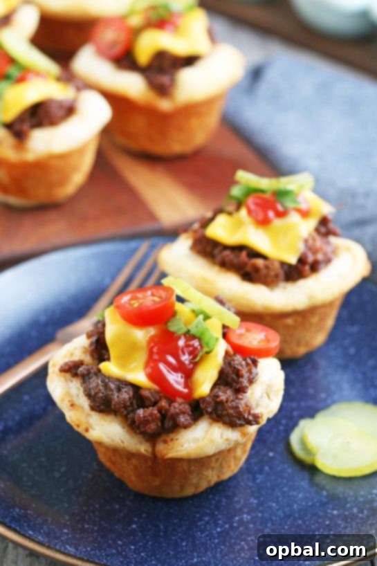 Cheeseburger Biscuit Poppers 11 A plate featuring two beautifully presented cheeseburger cups, garnished with fresh lettuce, demonstrating how appealing and ready to eat these homemade delights are.