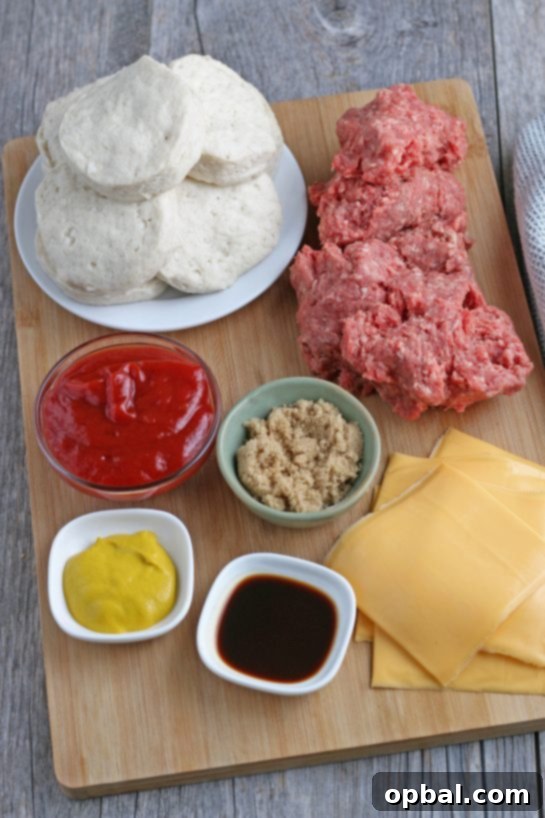 Cheeseburger Biscuit Poppers 3 All the fresh ingredients laid out on a wooden surface, including ground beef, refrigerated biscuits, cheese slices, ketchup, mustard, Worcestershire sauce, and brown sugar, ready to be assembled into delicious cheeseburger cups.
