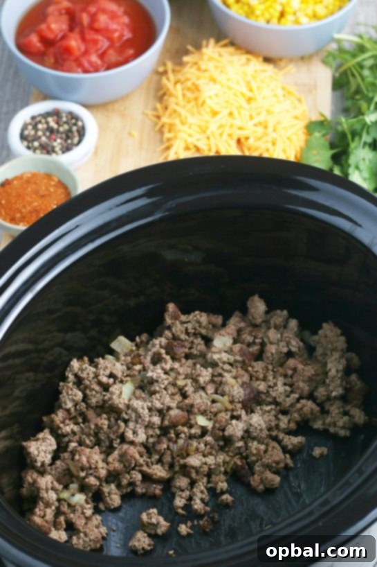 Easy Crockpot Creamy Taco Pasta 6 Now the cooked meat and onions go into our slow cooker for the taco pasta recipe!
