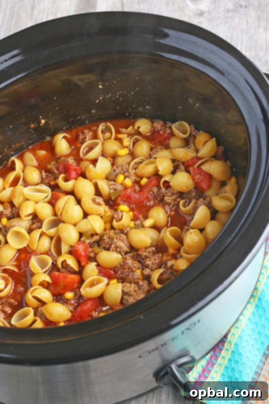 Easy Crockpot Creamy Taco Pasta 10 This image shows the pasta added to our slow cooker taco pasta and mixed up, cooking to perfection.