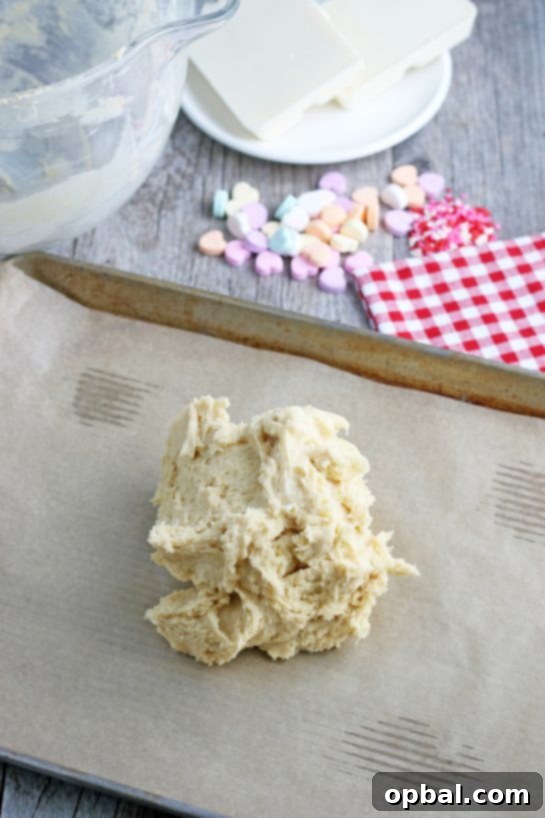 Now the ball of sugar cookie dough is placed on a lined cookie sheet so we can get it ready to be baked, ensuring it doesn't stick.