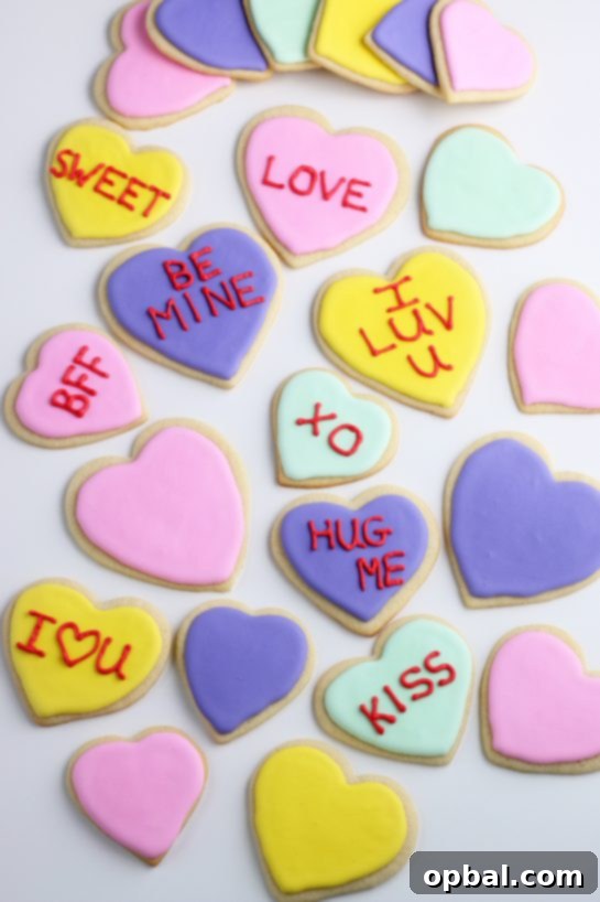 Crafting Edible Love Notes: Decorating Valentine's Conversation Heart Cookies 3 An inviting overhead view of freshly baked sugar cookies, some already adorned with colorful royal icing and sweet messages, showcasing a variety of simple yet charming designs ready for Valentine's Day festivities.