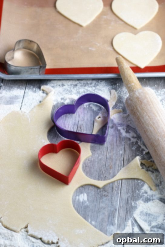 Crafting Edible Love Notes: Decorating Valentine's Conversation Heart Cookies 4 A baking sheet filled with freshly rolled sugar cookie dough, meticulously cut into charming heart shapes with cookie cutters, poised and ready for baking to become the foundation of our Valentine's creations.
