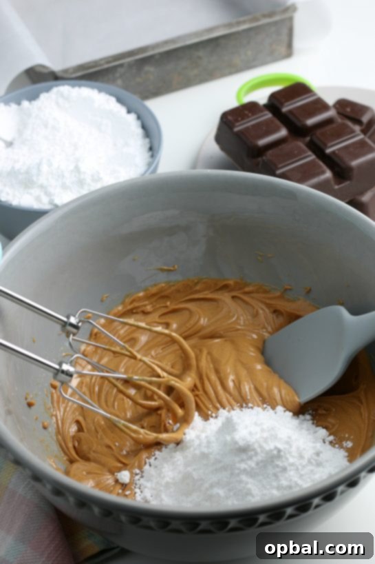 Decadent Chocolate Peanut Butter Eggs 7 The process of slowly incorporating powdered sugar into the peanut butter mixture, allowing the batter to thicken and achieve the ideal consistency for the egg centers.