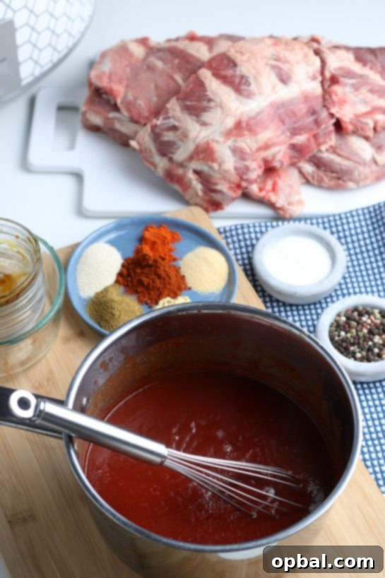 The homemade barbecue sauce simmering gently on the stovetop, a vital component that promises to make these BBQ ribs succulent.