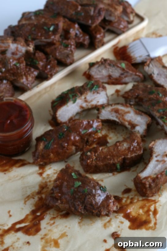 A beautifully presented platter of fully cooked crock pot ribs, gleaming with sauce and ready to be enjoyed as a hearty meal.