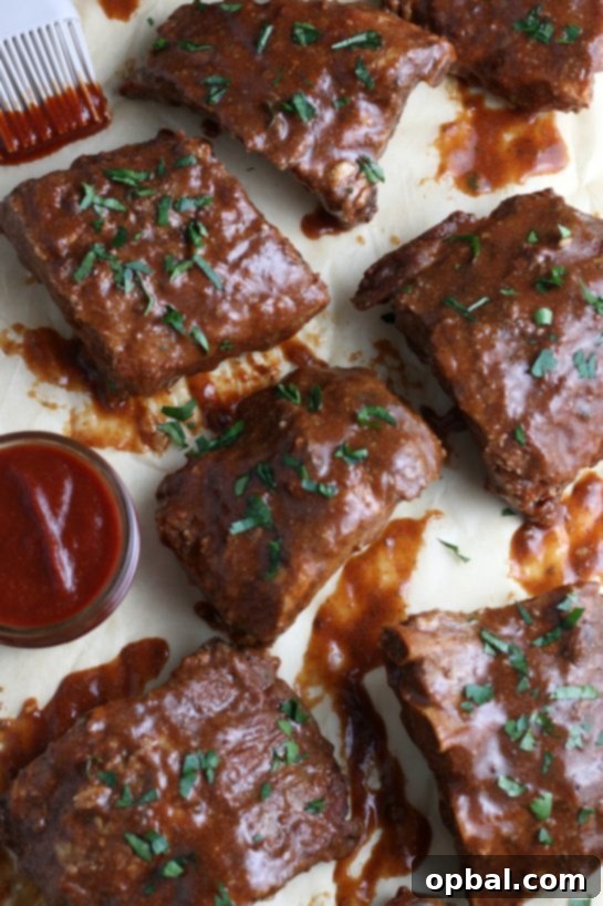 A detailed, top-down perspective of perfectly braised BBQ ribs from the crock pot, showing off their rich sauce and tender meat.