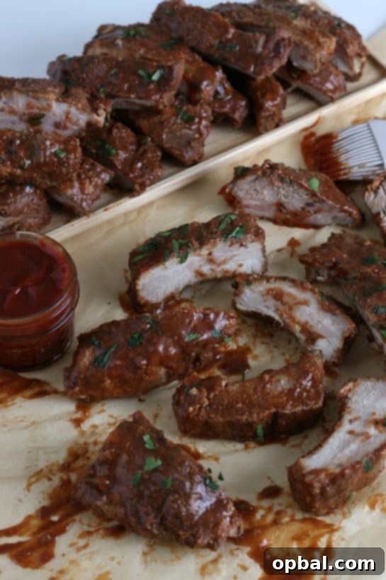 A stacked presentation of succulent slow cooker ribs on a serving tray, glistening with a rich, dark barbecue sauce, ready for guests.