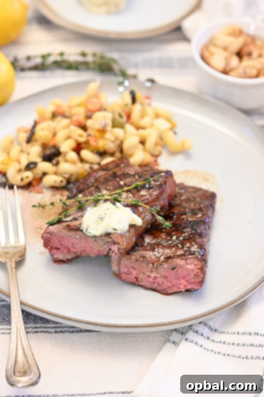 Fire-Kissed Strip Steak with Melting Herb Butter 2 Perfectly grilled strip steaks topped with melting herb compound butter, promising a gourmet dinner experience at home.