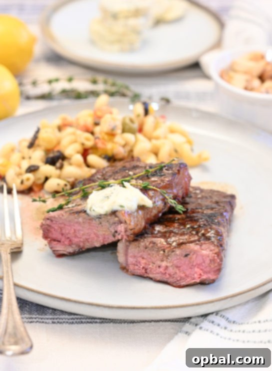 Fire-Kissed Strip Steak with Melting Herb Butter 7 Juicy grilled strip steaks generously topped with melting herb compound butter, presenting a gourmet dinner recipe for home.