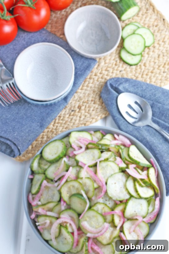 Overhead shot of the finished Cucumber Salad with serving utensils, showcasing the colorful ingredients.