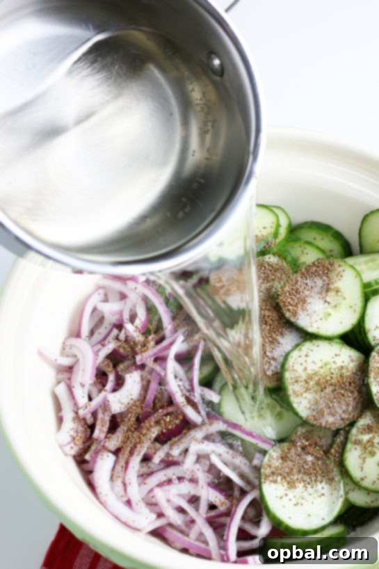 Pouring the dressing onto the cucumber salad, illustrating the final step before mixing.