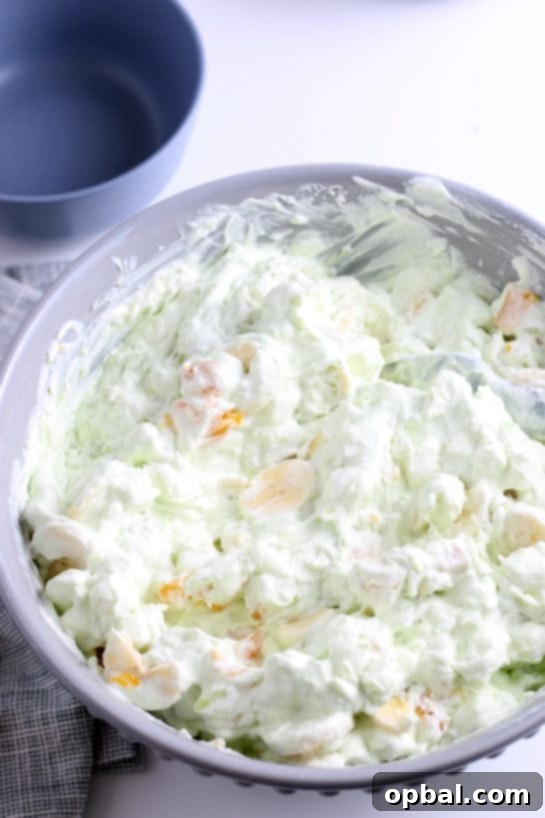 Pistachio Cloud Fruit Ambrosia 15 All the delicious ingredients for the pistachio fluff salad are thoroughly stirred together, ensuring a perfect blend of flavors and textures.