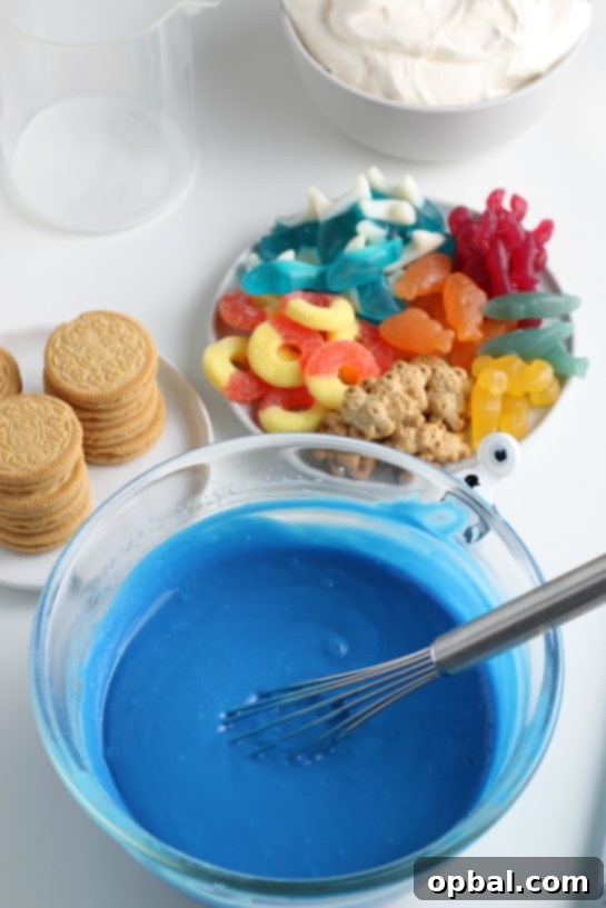 Seaside Pudding Parfaits 6 Adding blue food coloring to the vanilla pudding mix, transforming it into a vibrant ocean hue for the Beach Sand Pudding Cups.