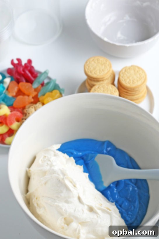 Seaside Pudding Parfaits 7 Gently folding in the whipped topping with the blue-tinted pudding to achieve a light and airy 'ocean' layer for the Beach Sand Pudding Cups.