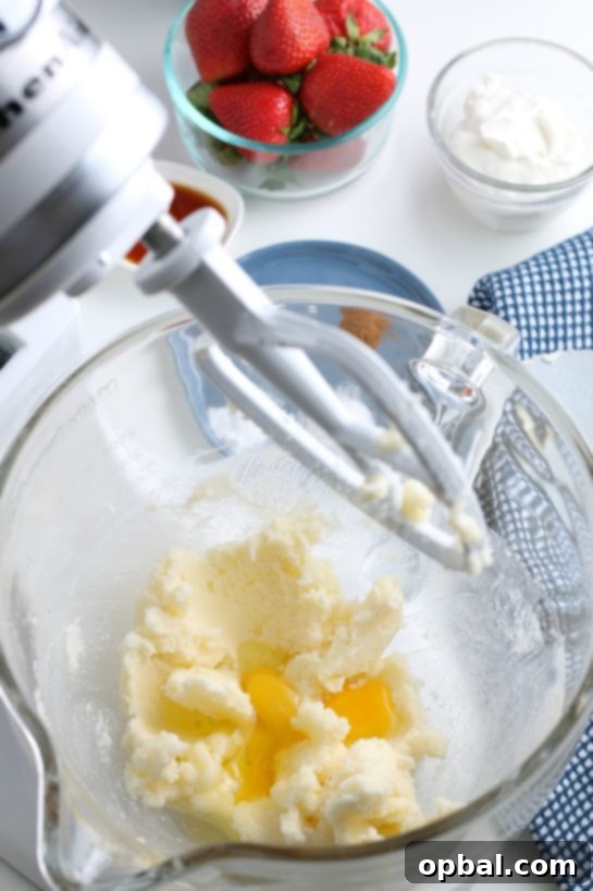 Luscious Strawberry Cream Bread 8 Eggs being added to the creamed butter and sugar in a stand mixer.