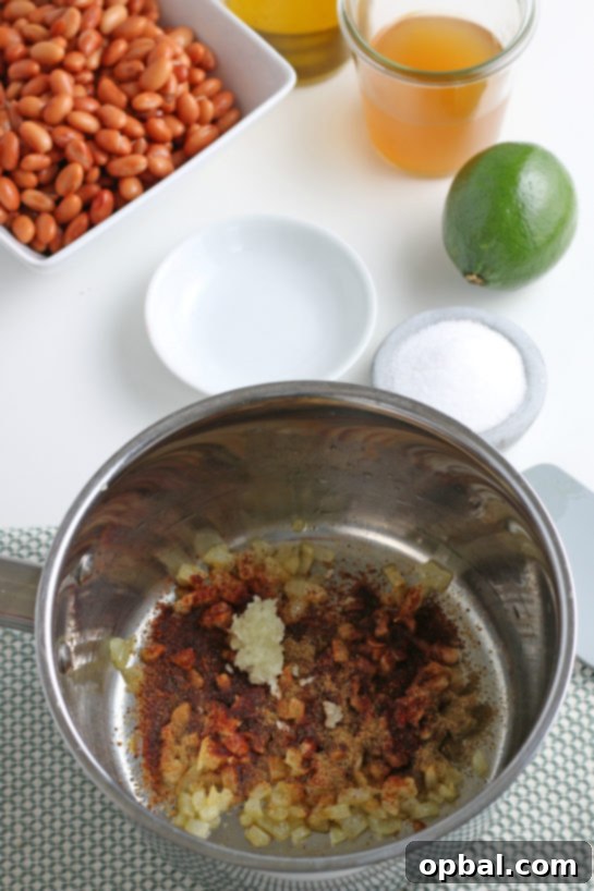 Adding fragrant spices like cumin and chili powder to the sautéed onions and garlic