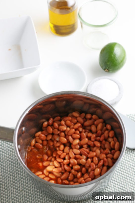 Adding rinsed pinto beans and broth to the pot, ready to simmer and absorb flavors