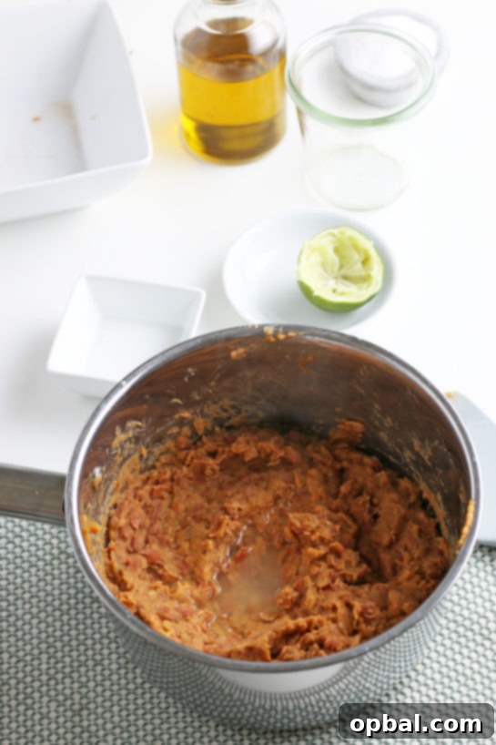 Overhead view of perfectly smashed pinto beans, showcasing their rich texture and color