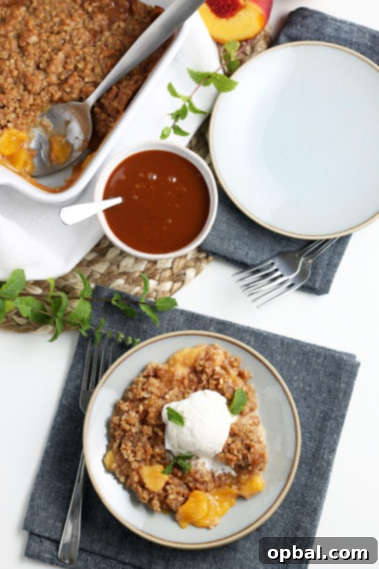 Sun-Kissed Peach Crumble 3 Close-up of a rustic fresh peach crisp, showcasing the vibrant peach filling and crunchy, golden-brown topping