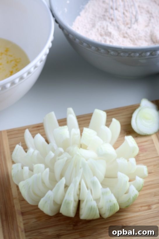 Golden Blossom Onion 11 Detailed shot of an onion being skillfully sliced to create its 'bloom' effect, fanning out like a flower, for the blooming onion recipe.